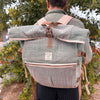 A sage hemp trekking rolling backpack with green and beige herringbone pattern and tan straps made of hemp materials