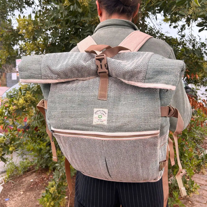 A sage hemp trekking rolling backpack with green and beige herringbone pattern and tan straps made of hemp materials
