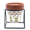 Herb garden candle with terracotta soy wax in white ceramic pot with geometric patterns and black metal stand
