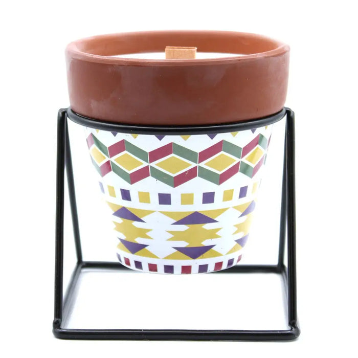 Herb garden candle with terracotta soy wax in white ceramic pot with geometric patterns and black metal stand