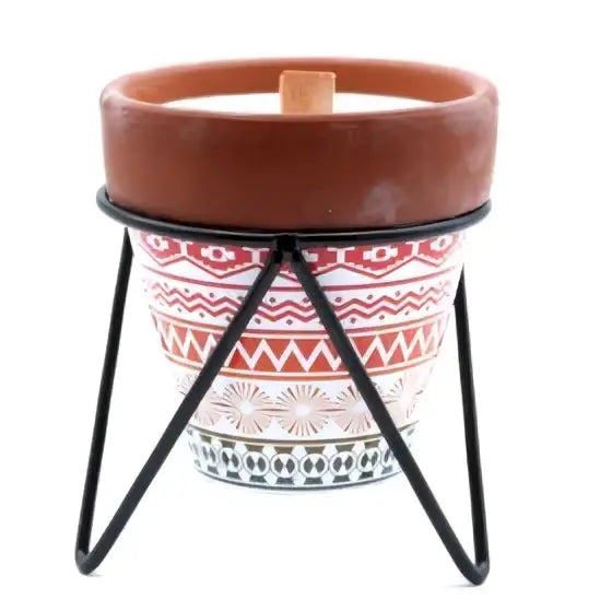 A terracotta herb garden scented candle holder with red and white geometric pattern on black metal stand with soy wax