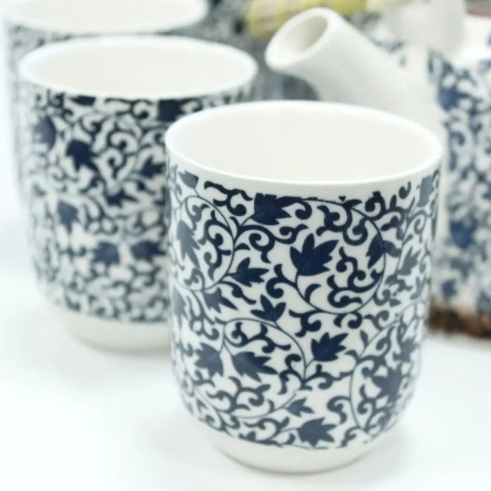 Blue and white ceramic mugs with intricate leafy vine patterns part of a herbal teapot set with blue pattern design