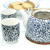Blue and white porcelain teapot with intricate leafy pattern and brown rimmed lid in herbal teapot set blue pattern