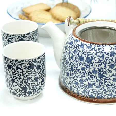 Blue and white porcelain teapot with intricate leafy pattern and brown rimmed lid in herbal teapot set blue pattern