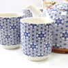 Blue and white ceramic teacup with geometric star patterns part of an herbal teapot set for brewing tea