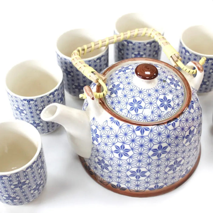 White ceramic herbal teapot set with blue geometric floral pattern and woven bamboo handle and brown glazed rim