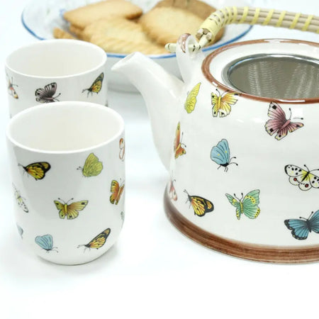 White ceramic teapot with colorful butterfly decals brown rim and metal infuser inside from herbal teapot set butterflies