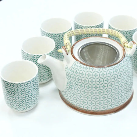 A ceramic herbal teapot set with a green mosaic pattern on white porcelain and a woven bamboo handle