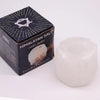 A translucent white himalayan salt crystal rock tealight holder with a rounded, natural crystalline texture