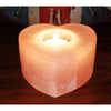 A heart-shaped himalayan salt tealight holder with a warm pinkish-orange hue and natural crystalline texture