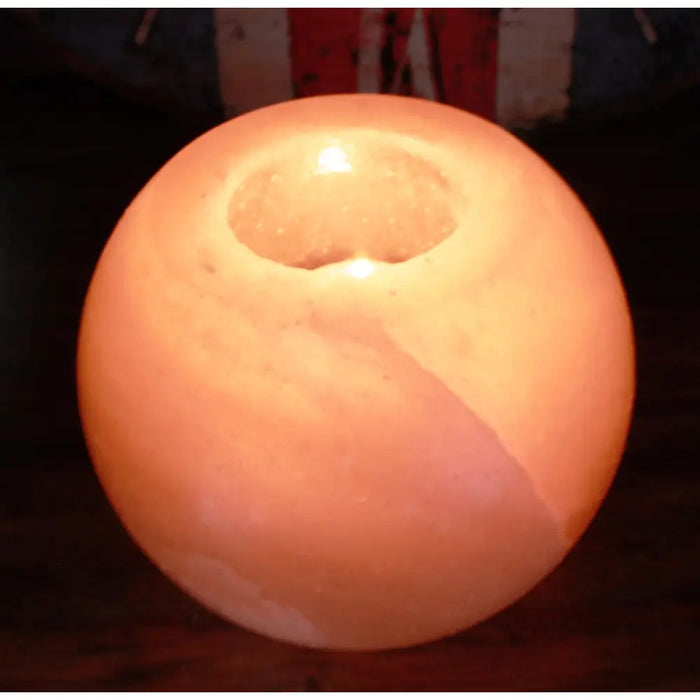 A warm peach-colored himalayan salt candle holder round tealight holder with a smooth natural stone texture and central hole