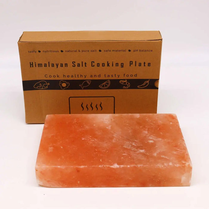 A rectangular himalayan salt cooking plate with a warm orange-pink hue and natural crystalline texture