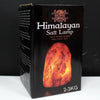 Himalayan salt lamp 2-3kg with glowing orange-red crystalline salt in black packaging showing natural mineral texture and home logo