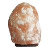 A himalayan salt lamp 20-25kg with a rough orange and white crystalline surface showing hygroscopic properties in humid conditions