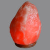A glowing pink himalayan salt lamp with a rough texture emitting a warm amber glow ideal for humid conditions and hygroscopic properties