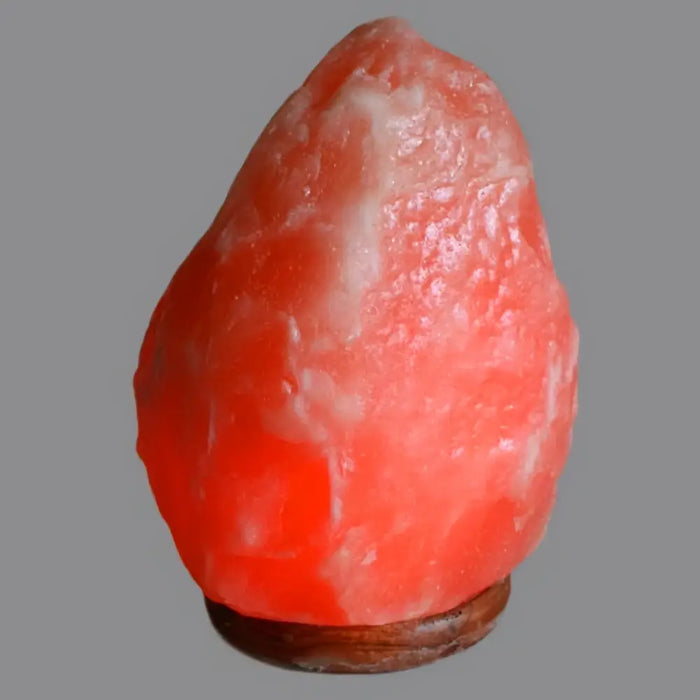 A glowing pink himalayan salt lamp with a rough texture emitting a warm amber glow ideal for humid conditions and hygroscopic properties