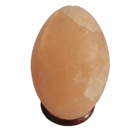 A smooth peach-colored himalayan salt lamp egg with natural white patches showing its hygroscopic properties