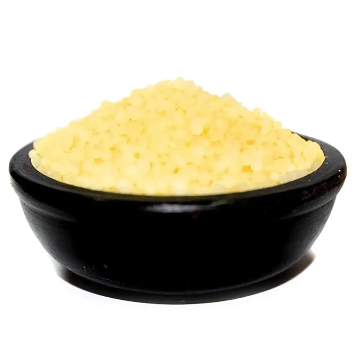 A black ceramic bowl filled with pale yellow coarse salt granules with subtle floral daisy fresh notes for bathroom use
