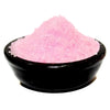 A bowl of coarse pink salt granules in a black ceramic bowl with subtle midnight roses notes for bedroom use