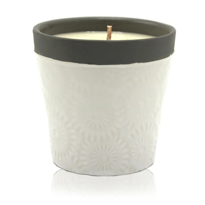 White ceramic candle jar with embossed floral pattern and black rim filled with forever vanilla soy wax