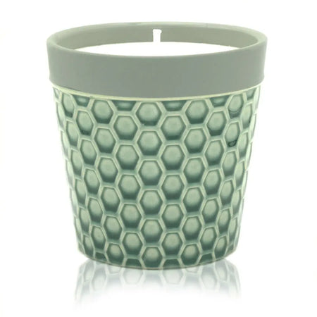 A sage green ceramic Home is Home candle pot with textured honeycomb pattern and light gray rim for soy wax fruit basket