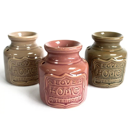 Three beige ceramic home oil burners with raised love a home sweet home emblems on the front