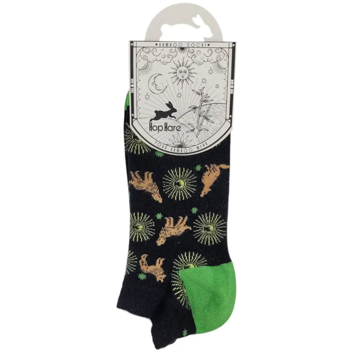 Black and green bamboo trainer socks with tan rabbit sunburst and clover patterns on a dark background