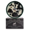 A white hop hare crystal magic flower candle with black obsidian and dried botanicals in a green tin on its box