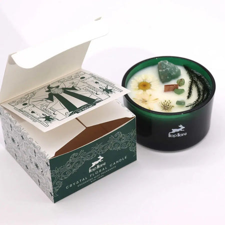 Deep green glass candle jar with white wax blend dried flowers crystals and pine sprigs in hop hare crystal magic flower candle