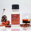 A clear glass bottle with black ribbed cap and orange label of hot chocolate fragrance oil by ancient wisdom england
