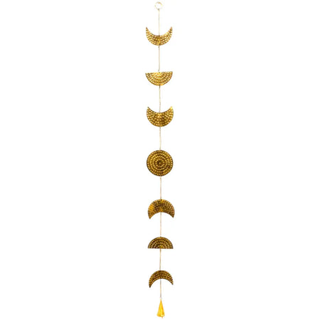 Golden brass moon phases wall hanging with hammered texture and small yellow tassel at the bottom with a bell