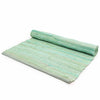 A rolled aqua handloom cotton rug with a textured woven pattern and subtle shade variations from indian handloom