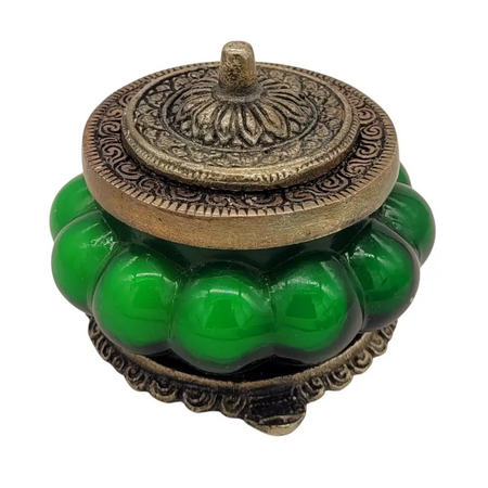 Green jade-like indian scented candle in an antique style glass jar with ornate brass lid and floral patterns