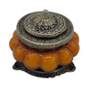 Ornate silver toned lid with floral engraving on amber bead base glass jar candle in patchouli amber antique style