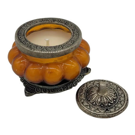 Ornate amber glass jar candle holder with silver metal lid and base in antique style patchouli amber design