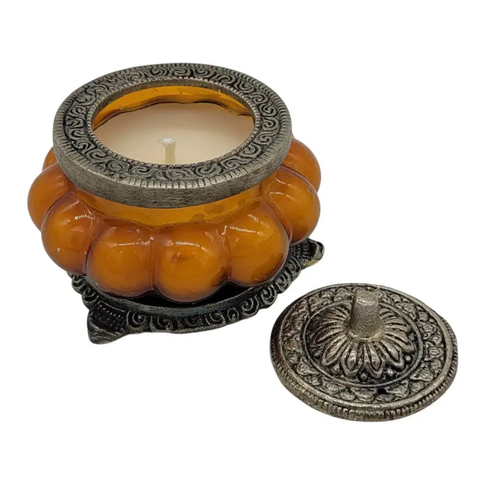 Ornate amber glass jar candle holder with silver metal lid and base in antique style patchouli amber design
