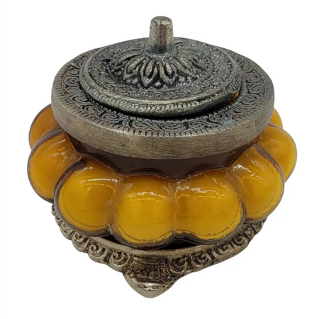 Ornate silver toned metal incense burner with amber glass segments in an antique style glass jar for precious sandal scent