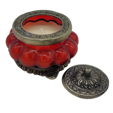 Red glass indian scented candle in antique style glass jar with white metal ornate lid and base