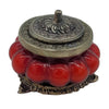 Red glossy ceramic incense burner with ornate white metal lid and base in antique style glass jar with floral patterns