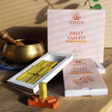A pale yellowish green palo santo incense smudge brick neatly arranged in a white ishom box with matching packaging