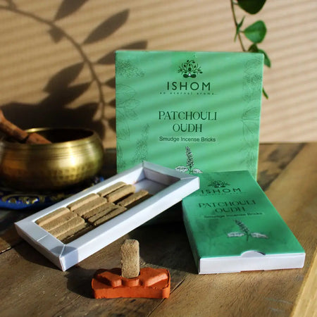 Green ishom patchouli oudh incense smudge bricks in a white box with an orange ceramic burner stand for smudge bricks