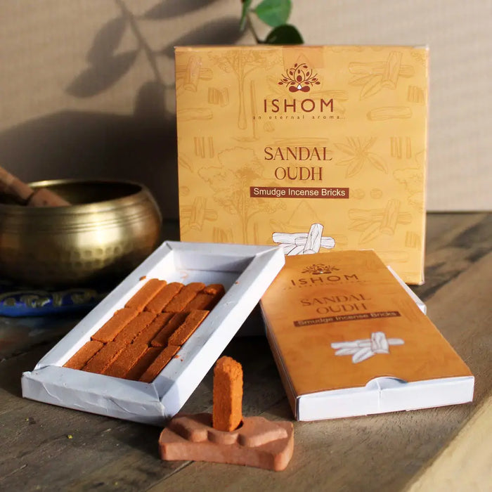 A single orange-brown sandalwood incense smudge brick standing upright on a matching terracotta base for smudging