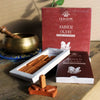A single amber oudh incense smudge brick standing upright in a terracotta ceramic holder for smudge bricks use