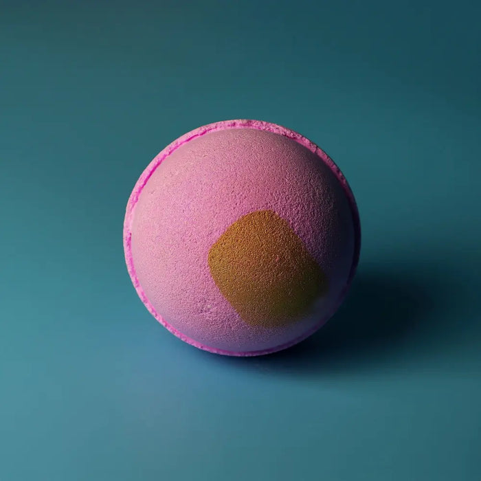 Jumbo bath bomb pink charlotte with a textured surface and golden yellow patch made with sodium lauryl sulfoacetate and peel oil