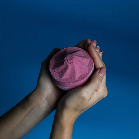 A jumbo pink bath bomb with a faceted geometric design made with sodium lauryl sulfoacetate razzle dazzle