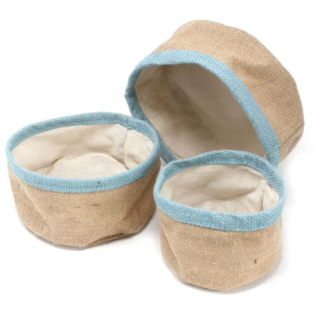 Set of three beige jute baskets with teal trim and cream interior lining made from burlap for storage use