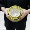 Set of three nested handwoven jute baskets with lime green rims and cream interior linings for storage use