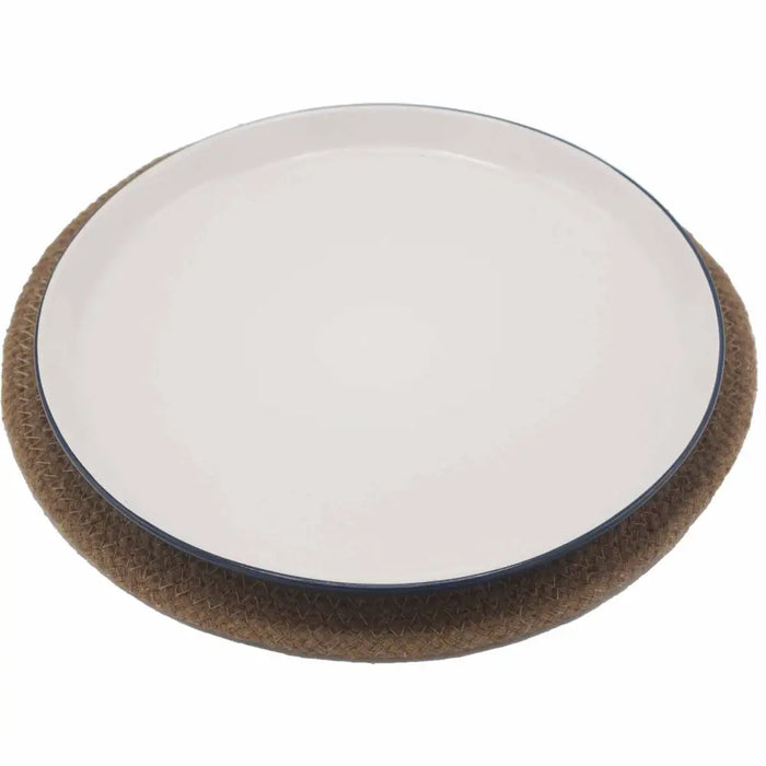 Cream-colored ceramic plate with dark blue rim placed on natural jute and cotton woven place mat base