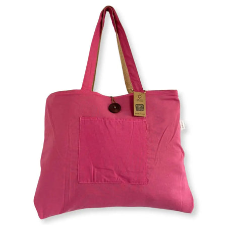 A vibrant pink jute and cotton tote bag with tan straps and a front pocket with a dark wooden button