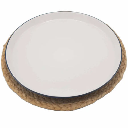 White ceramic plate with navy rim on a woven jute place mat with mandala design